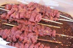 Marinated pork tenderloin strips put onto sticks