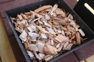 Placing the wood chips into the smoke box