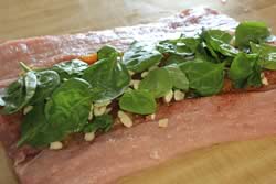 A layer of almond slices and baby spinach leaves