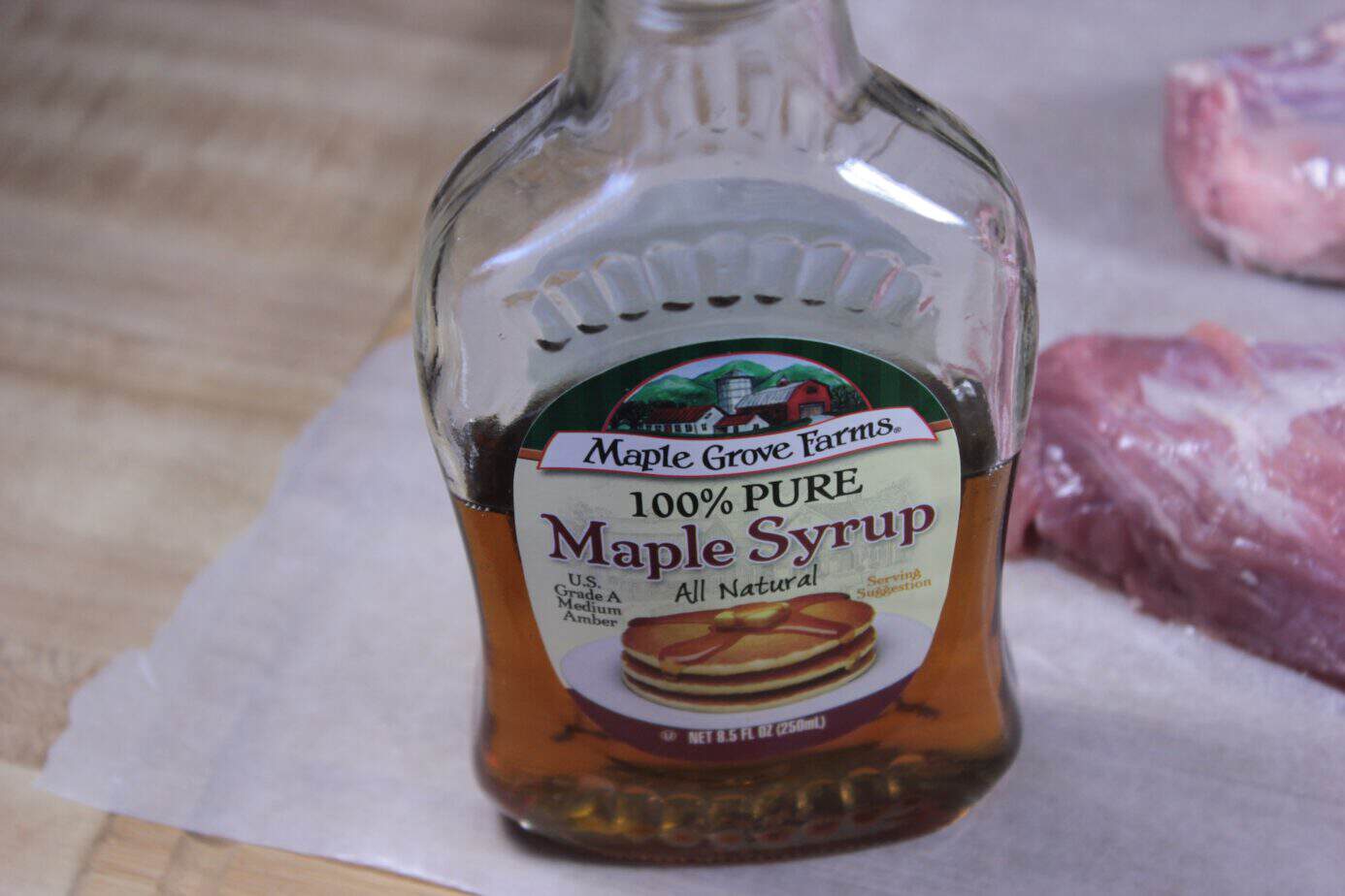 Smoked Pork Tenderloin Recipe 38 bottle of pure maple syrup next to some raw pork tenderloins