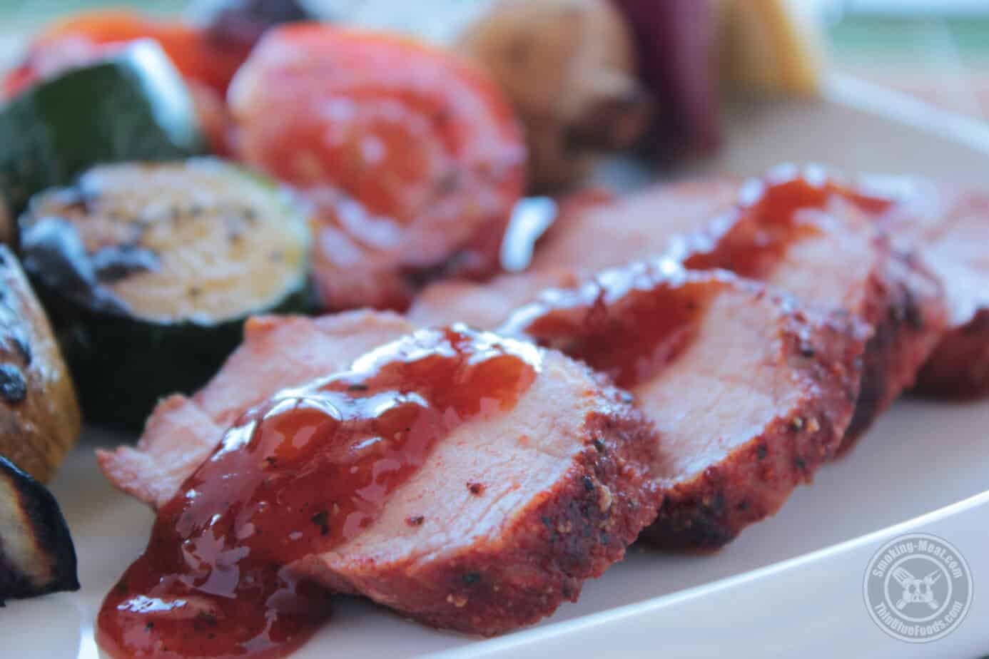 Smoked Pork Tenderloin Recipe 44 smoked pork tenderloin sliced and plated with peach chutney drizzled across the top.
